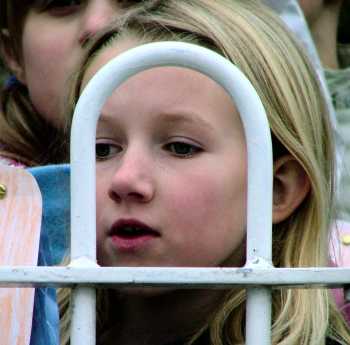 Girl watching behind railings
